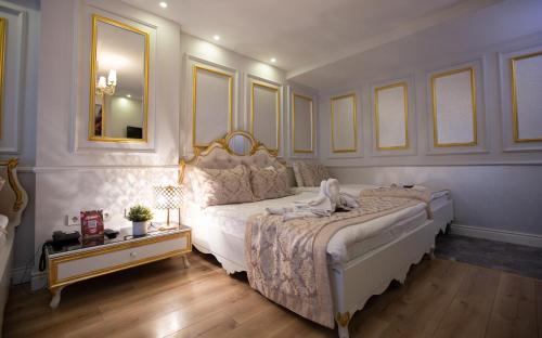 Sirkeci Ersu Hotel & SPA في إسطنبول: غرفة نوم بسرير كبير ومرآة