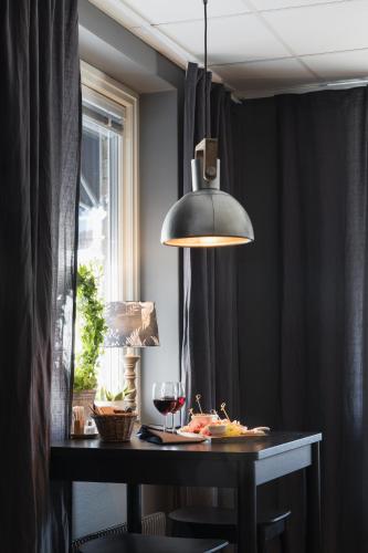 a table with a glass of wine and aendant light at Hotell Leksand in Leksand