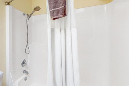 a shower with a white shower curtain in a bathroom at Friend-Ship in Rockaway Beach
