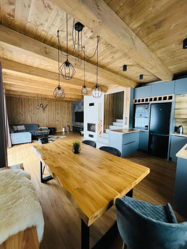 cocina y sala de estar con mesa de madera en CHALETY MÝTO POD ĎUMBIEROM, en Mýto pod Ďumbierom