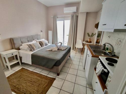 een slaapkamer met een bed en een keuken met een wastafel bij Nereides Apartments in Agios Gordios