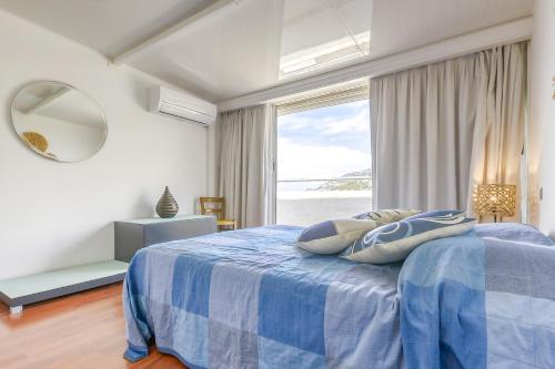 una camera da letto con un letto con una coperta blu e una finestra di Gauguin 44 Almadrava Roses - Immo Barneda a Roses