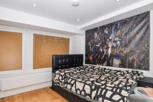 a bedroom with a bed and a large painting on the wall at New Flat (12 mins Central London/Gatwick Airport) in Croydon
