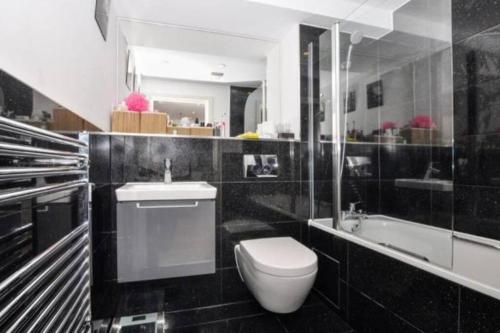 uma casa de banho com um WC, um lavatório e uma banheira em New Flat (12 mins Central London/Gatwick Airport) em Croydon