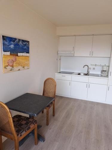 a kitchen with a table and chairs and a sink at THOGE Koksijde in Koksijde
