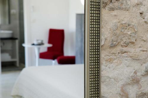 a mirror leaning against a wall with a red chair at Luxory D-Rooms in Vela Luka