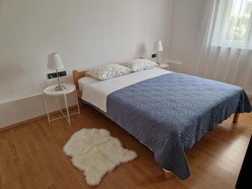 1 dormitorio con cama y alfombra blanca en Apartman Jurjević, en Krk