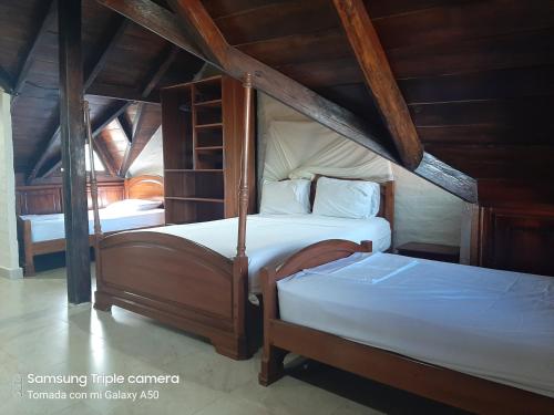 two beds in a room with a attic at Hotel La Vista in Canoa