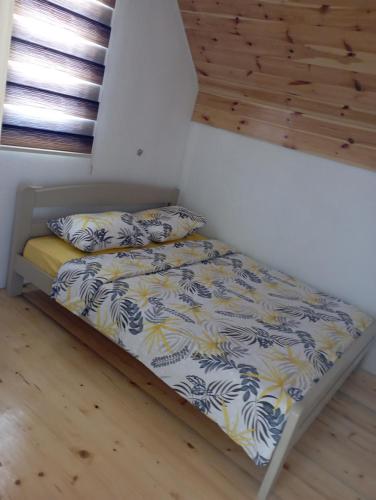 Cama pequeña en habitación con sábanas y almohadas en Apartman JOVANA, en Žabljak