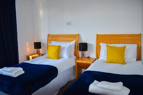 布里斯托的住宿－The Hathway Walk Home，一间卧室配有两张带黄色和蓝色枕头的床