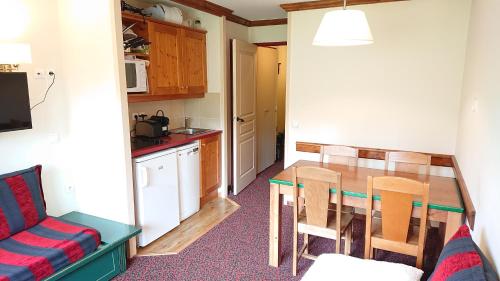 a small kitchen with a table and a couch at Plagne Soleil - Montsoleil -Ski aux pieds-5 personnes in Plagne Villages