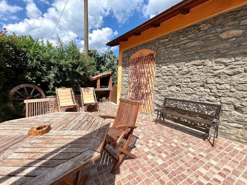 a patio with two chairs and a wooden table and bench at Cà dè Armando - Val di Vara e Cinque Terre in Riccò del Golfo di Spezia