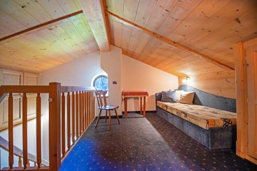 a bedroom with a bed and a chair in a room at Agriturismo Apartments Tuene in Ortisei
