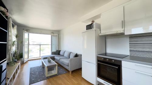 a kitchen and a living room with a couch at Sandnes condo in Sandnes