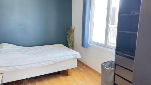 a blue room with a bed and a window at Sandnes condo in Sandnes