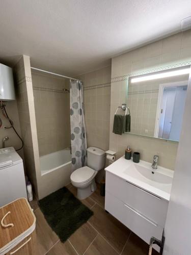 uma casa de banho com um WC, um lavatório e uma banheira em Appartement 1 chambre climatisé avec 3 piscines à 200 m de la plage em Empuriabrava
