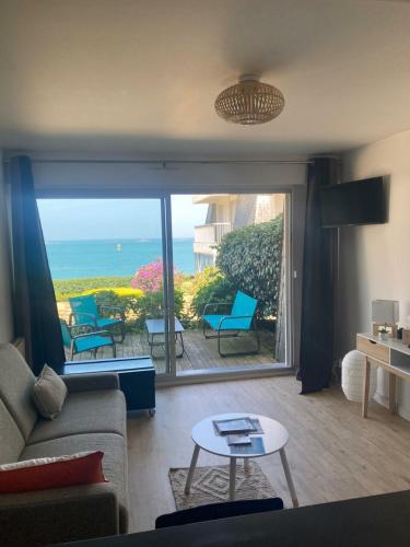 un salon avec vue sur l'océan dans l'établissement Les pieds dans l'eau, à Saint-Quay-Portrieux