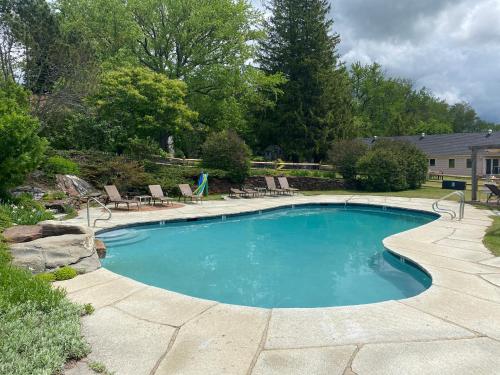 una gran piscina con sillas y un patio en The Wildflower Inn en Lyndonville