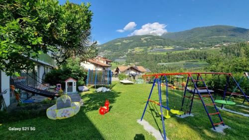 un patio con un parque infantil con columpios en Laimerhof, en Rifiano