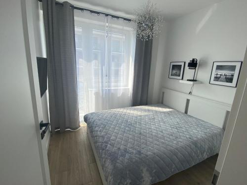 a bedroom with a bed and a window at Apartament KLIFOWA REWAL przy plaży in Rewal