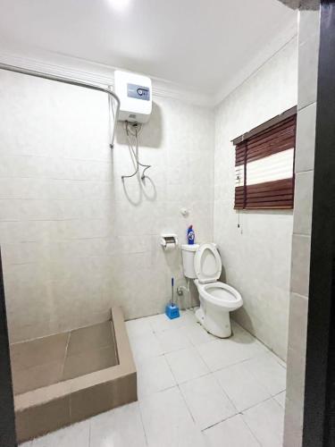 a white bathroom with a toilet and a window at Bronx Suite by Jaynice Homes in Lekki