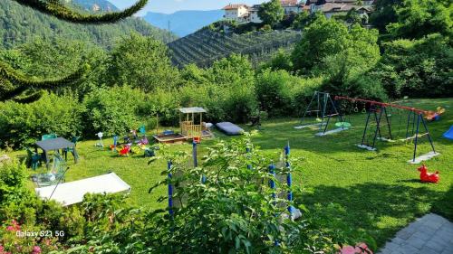 a garden with a playground and a swing set at Laimerhof in Rifiano