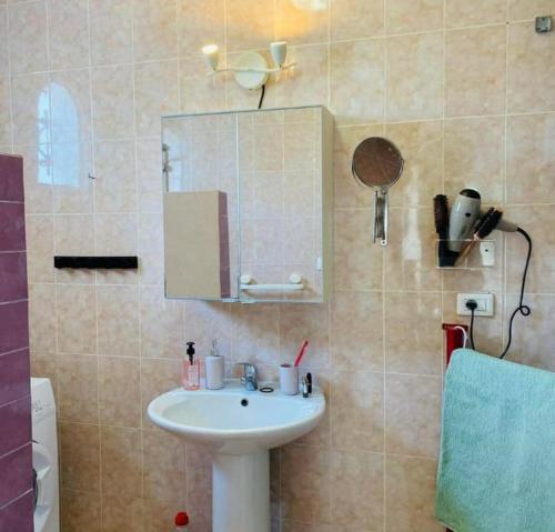 a bathroom with a sink and a mirror at Mille & une nuit in Al Maqārisah