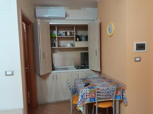 a small kitchen with a table and a table and chairs at Affittacamere Certe Notti in Sala Consilina