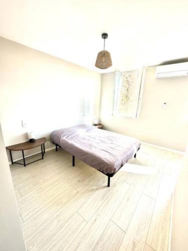 Ce lit se trouve dans un dortoir doté de parquet. dans l'établissement Coquette maison climatisée, à Pechbonnieu