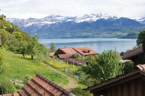 einen Blick auf einen See mit Bergen im Hintergrund in der Unterkunft B&B Schönörtli in Gunten