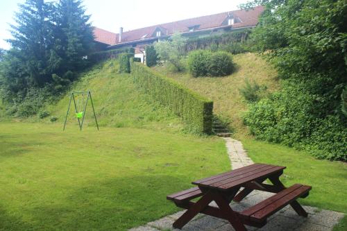 a wooden bench in a field with a swing at Pension Formanka in Splzov