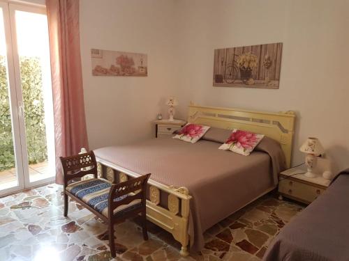 a bedroom with a bed and two chairs and a window at B&B CARRUBBELLE in Ragusa
