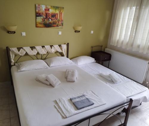 a large white bed with towels on top of it at Agnanti Studios in Afitos