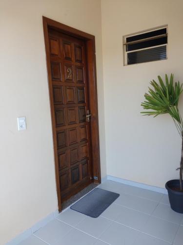 a wooden door in a room with a potted plant at Hospedagem Domiciliar em Lucas do Rio Verde in Lucas do Rio Verde