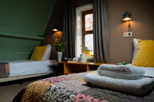 a bedroom with a bed with towels on it at Hotel Stedswal in Sloten