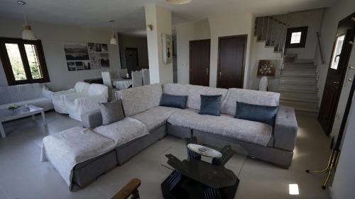 a living room with a large couch and chairs at Villa Faihs in Afissos