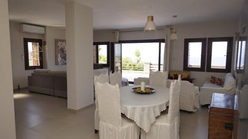 a dining room and living room with a table and chairs at Villa Faihs in Afissos