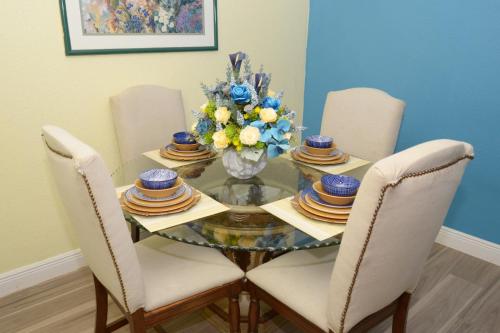 einen Esstisch mit Stühlen und eine Vase aus Blumen in der Unterkunft Cottage by Jubilee in Freeport
