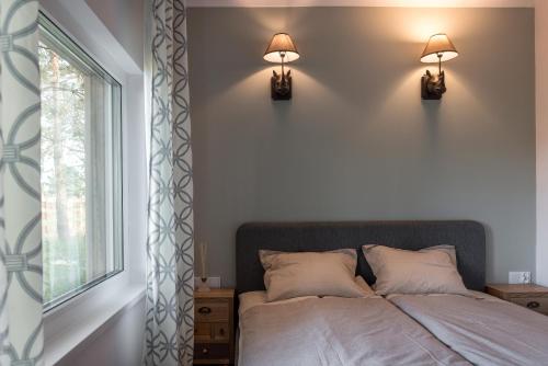 een slaapkamer met een bed met twee lampen aan de muur bij Kruszkanawierzbie in Kruszka