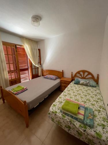 a bedroom with two beds and a window at Alcossebre, Apartamentos Hibiscus in Alcossebre