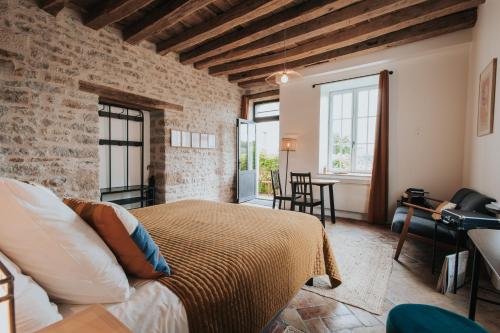 sypialnia z łóżkiem i ceglaną ścianą w obiekcie Les Cabottes w mieście Change