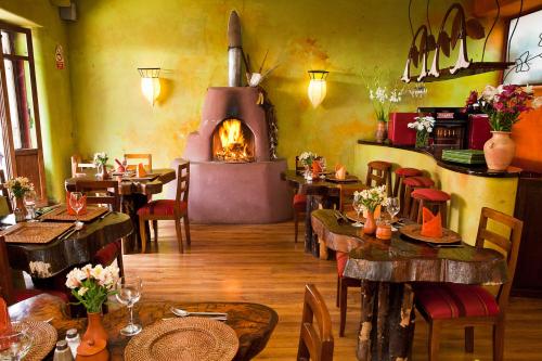 un restaurante con mesas y un horno de leña en Pisac Inn, en Písac