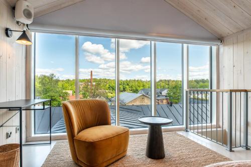 a living room with a chair and a large window at Billnäsin ruukki in Billnäs