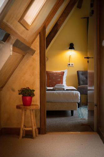 a attic room with a bed and a table at Hotel Stedswal in Sloten