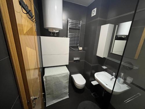 czarna łazienka z toaletą i umywalką w obiekcie Seaview Apartment Zetagradnja w Barze