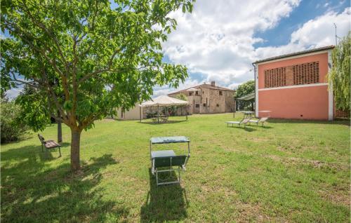 a park with benches and a tree and a building at Cozy Home In San Quirico Dorcia in San Quirico dʼOrcia