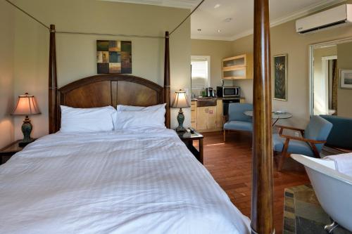a bedroom with a large bed and a bathroom at Above the Beach Guest Suites in Penticton