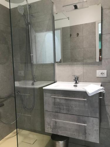 een badkamer met een wastafel en een douche bij Hotel Bersagliere in Laglio