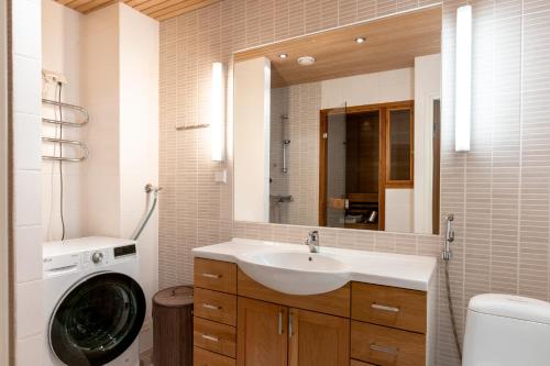 een badkamer met een wastafel en een wasmachine bij 2ndhomes Helsinki Center 2BR 103 m2 Deluxe Apartment with Sauna and Balcony in Helsinki