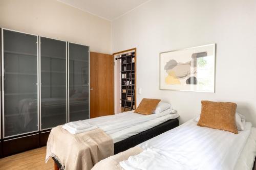 een slaapkamer met 2 bedden en een glazen wand bij 2ndhomes Helsinki Center 2BR 103 m2 Deluxe Apartment with Sauna and Balcony in Helsinki